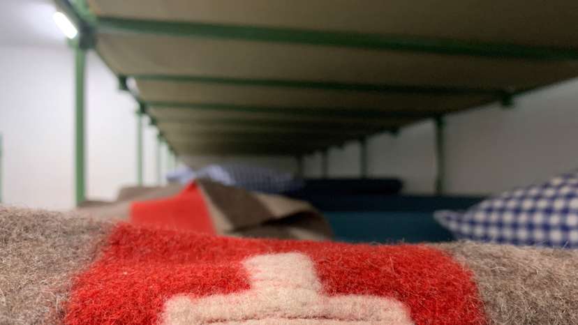 A Swiss flag is seen on a bunk bed are seen in the atomic shelter underneath the civil protection building in Gollion