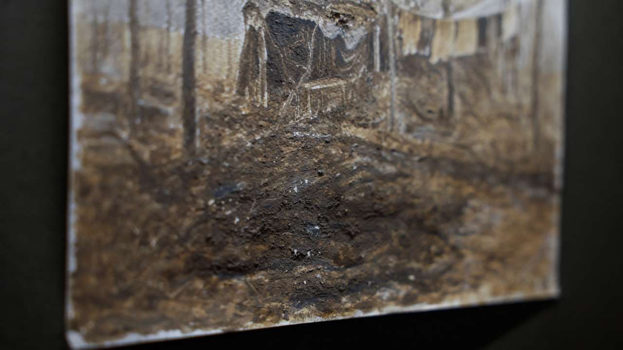 Trench mud is visible on a fragment of a painting displayed at the exhibition of a Ukrainian serviceman Bazylewicz with draws pictures with mud, clay and ashes from a frontline in Kyiv