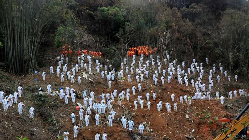 FILE PHOTO: Rescue workers stand in a silent tribute to mourn plane crash victims in Wuzhou