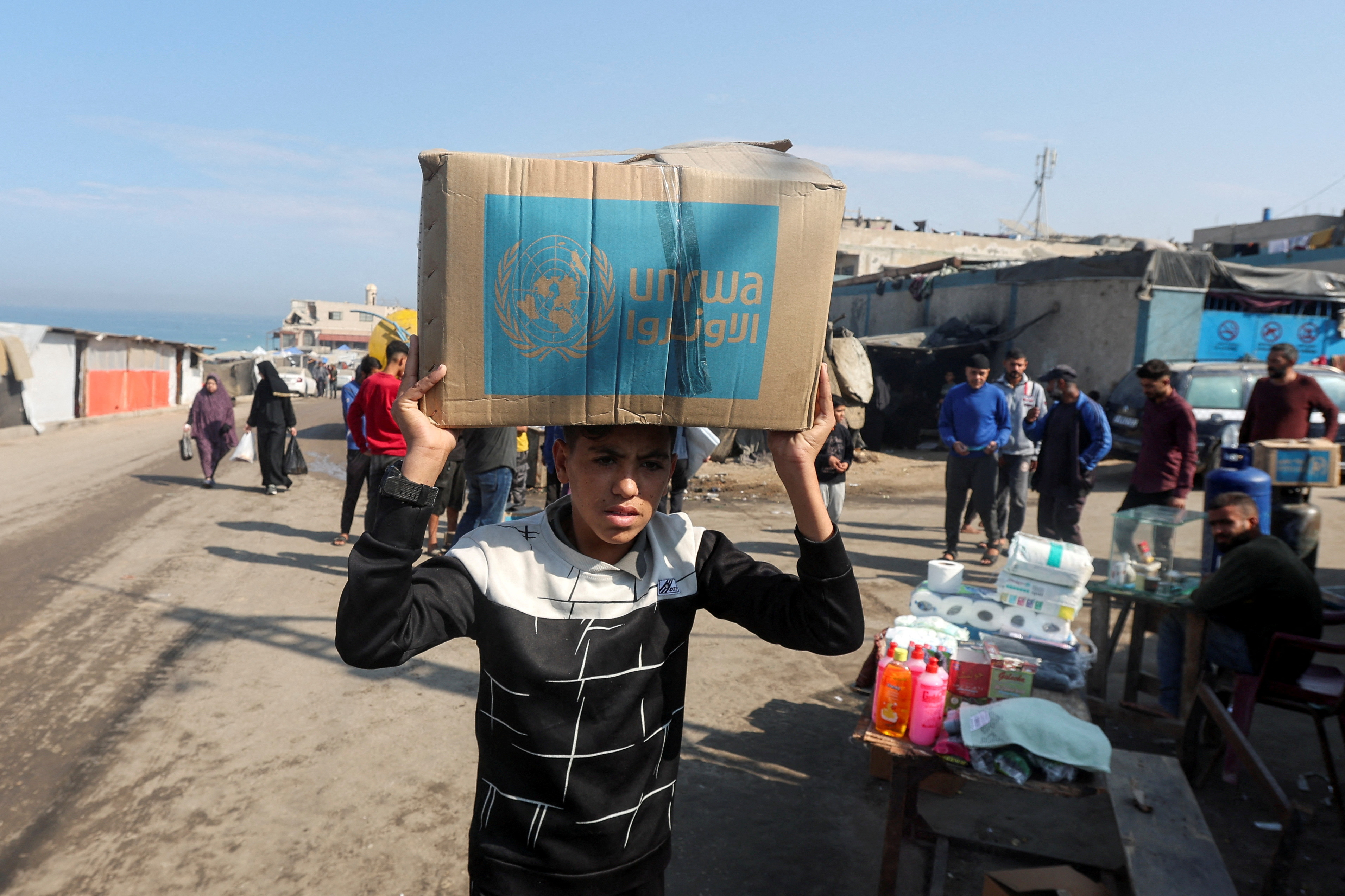 Palestinians receive aid from UNRWA in Deir Al-Balah, central Gaza Strip