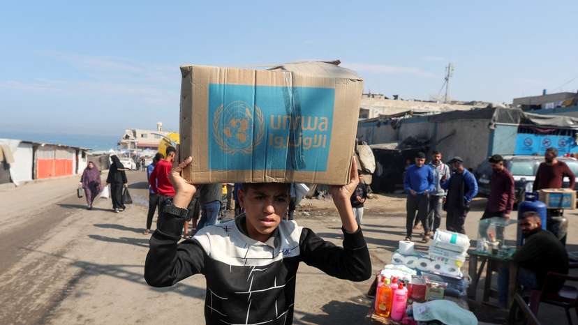 Palestinians receive aid from UNRWA in Deir Al-Balah, central Gaza Strip