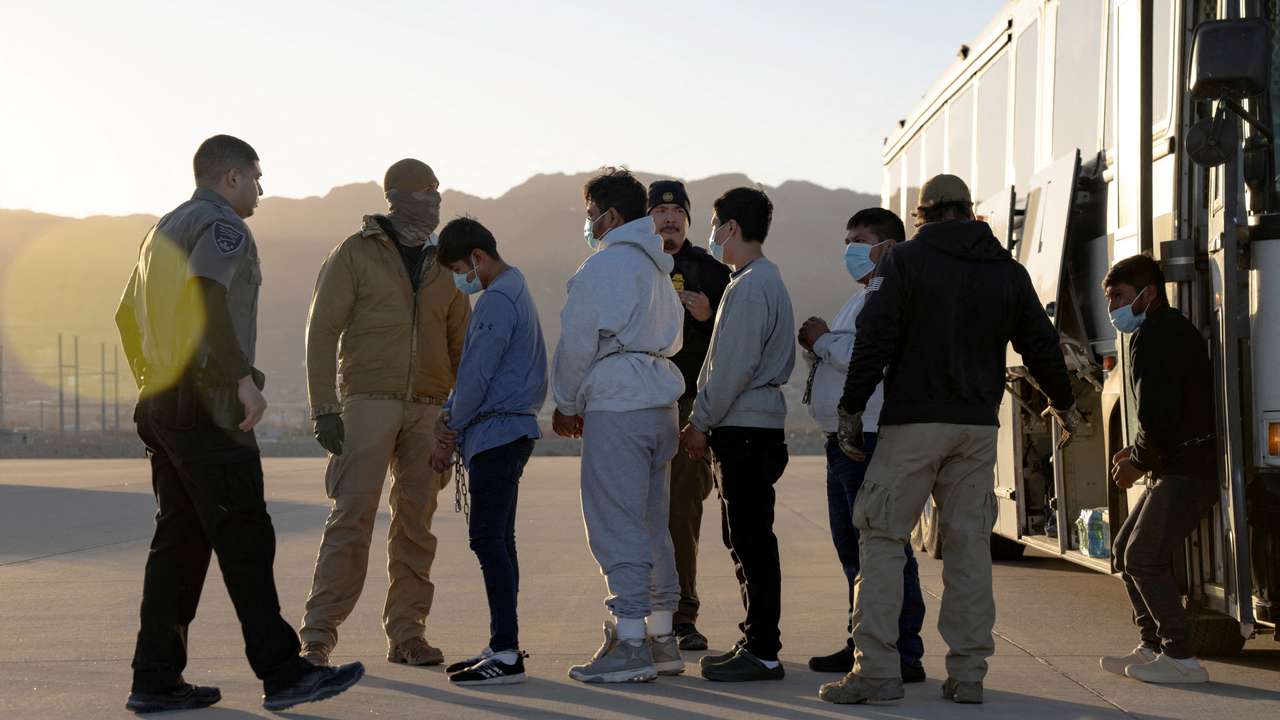 FILE PHOTO: U.S. Customs and Border Protection security agents guide a group of detained migrants to board a removal flight