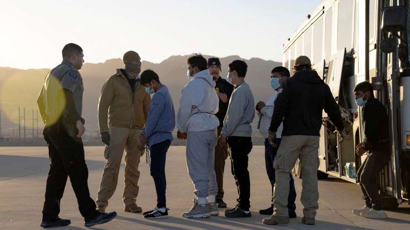 FILE PHOTO: U.S. Customs and Border Protection security agents guide a group of detained migrants to board a removal flight