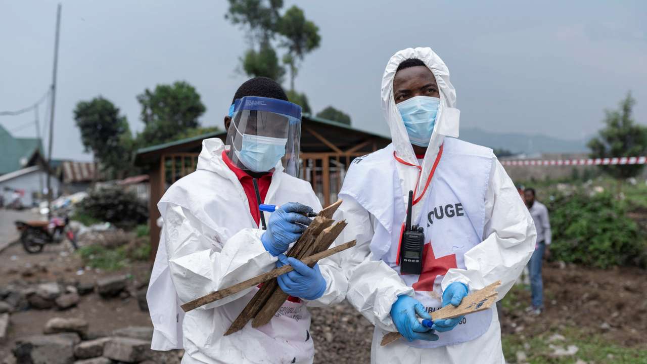 Red Cross team members proceed with the burial of victims of the fighting, at ITIG Cemetery, in Goma
