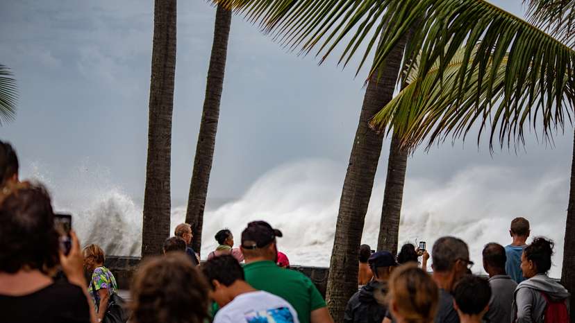 People look at high waves approaching the shore amid Cyclone Belal, in Saint-Denis on Reunion Island