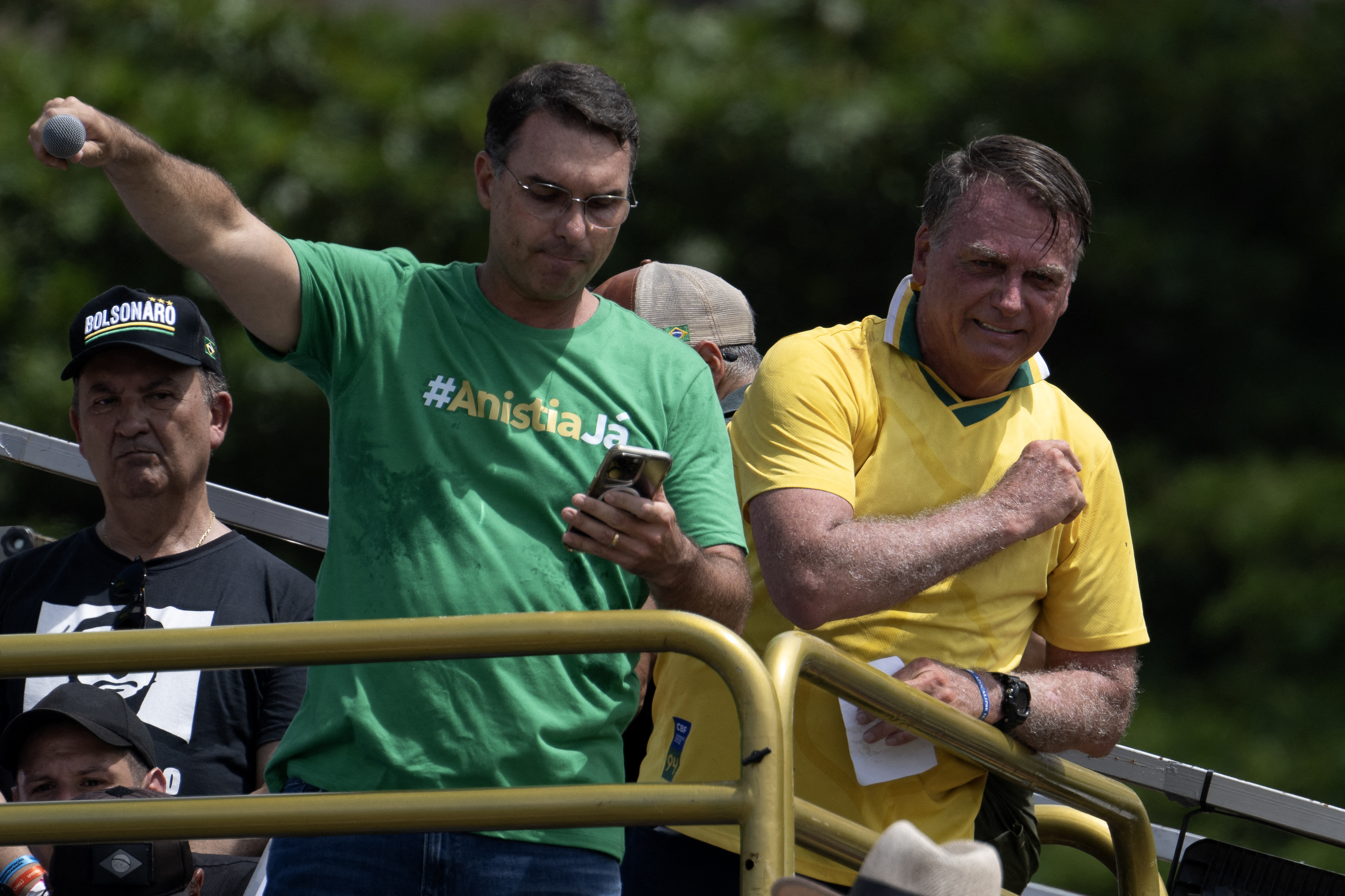 O ex-presidente do Brasil Jair Bolsonaro (à direita) e seu filho, o senador Flávio Bolsonaro, participam de um ato em Copacabana, no Rio de Janeiro, em 16 de março de 2025.