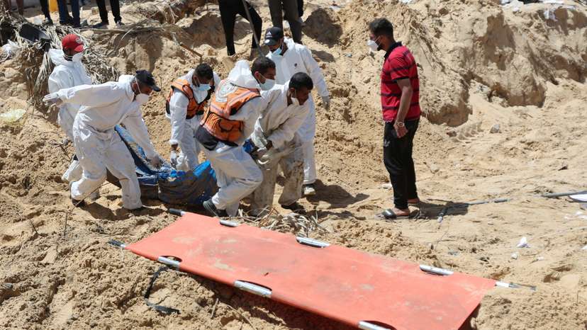 People work to move into a cemetery bodies of Palestinians killed during Israel's military offensive and buried at Nasser hospital, in Khan Younis