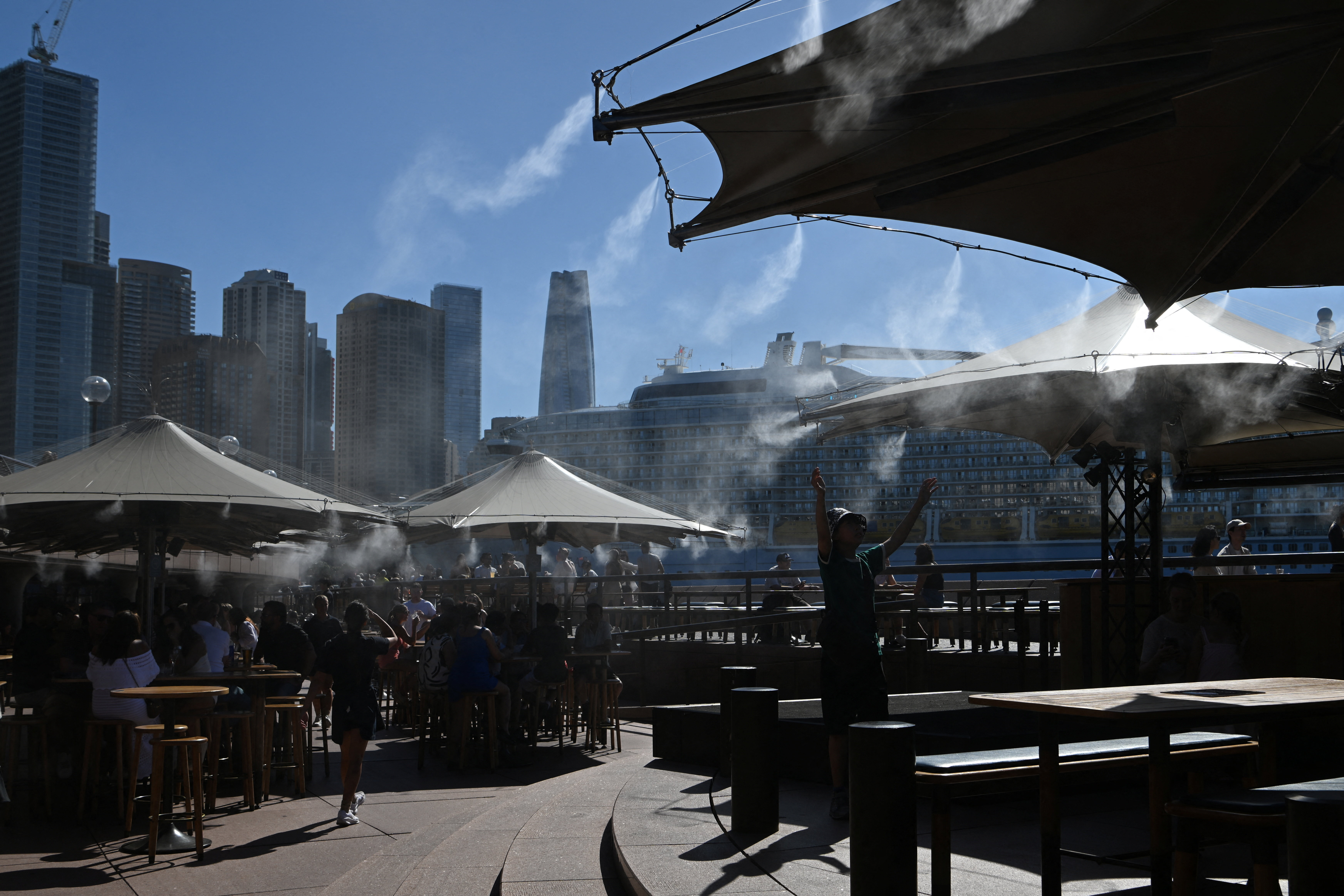 People cool off under a water mist at Circular Quay