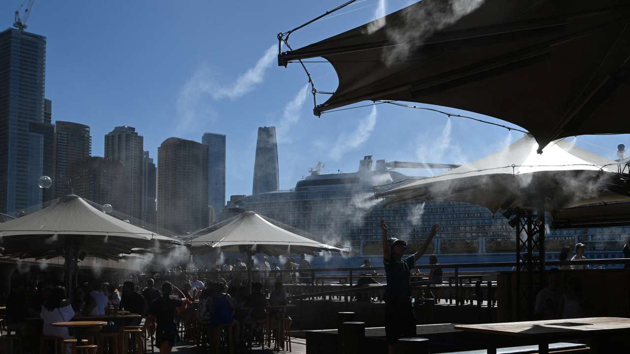 People cool off under a water mist at Circular Quay