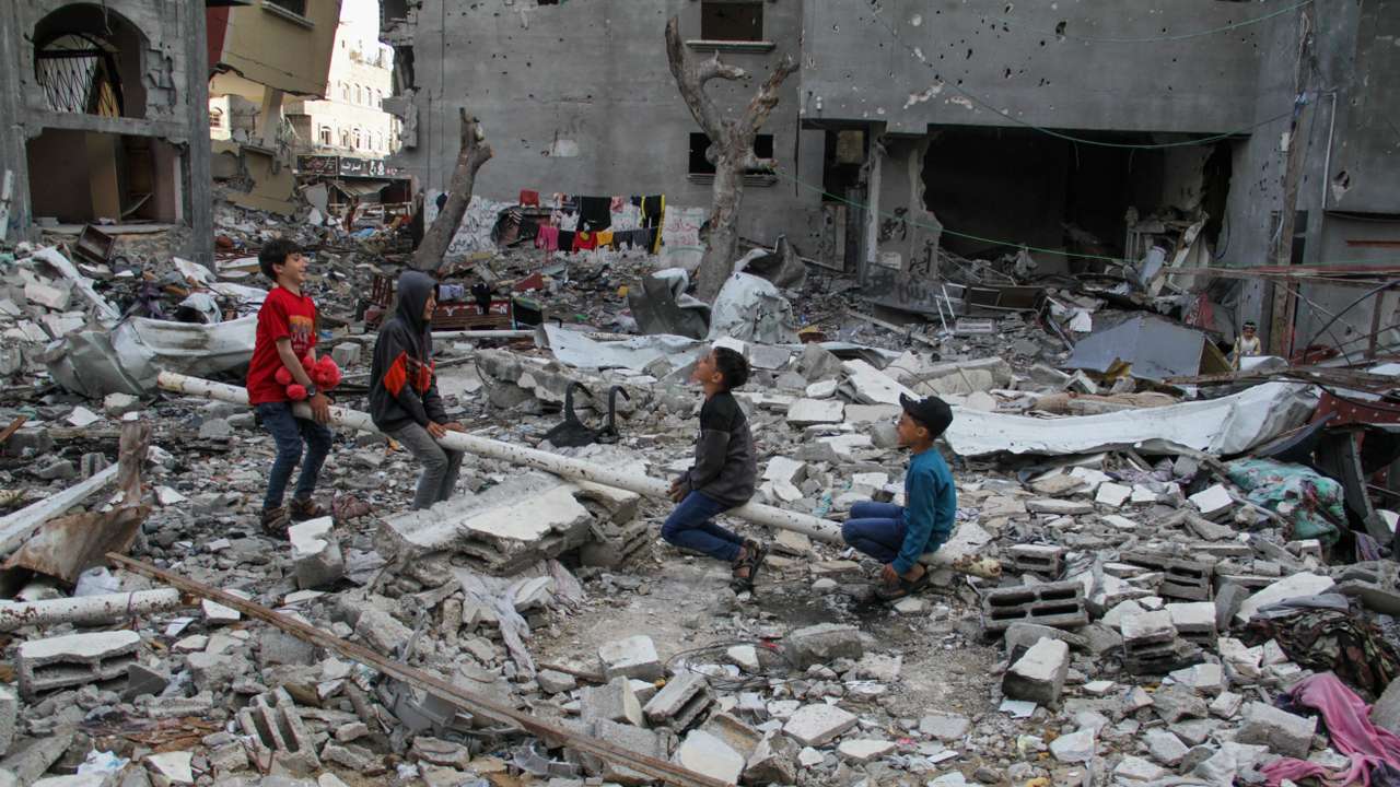People sit amid rubble during Eid al-Fitr, in Gaza City