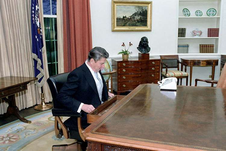 FILE PHOTO: Ronald Reagan sitting at the Oval Office desk following his inaugural parade