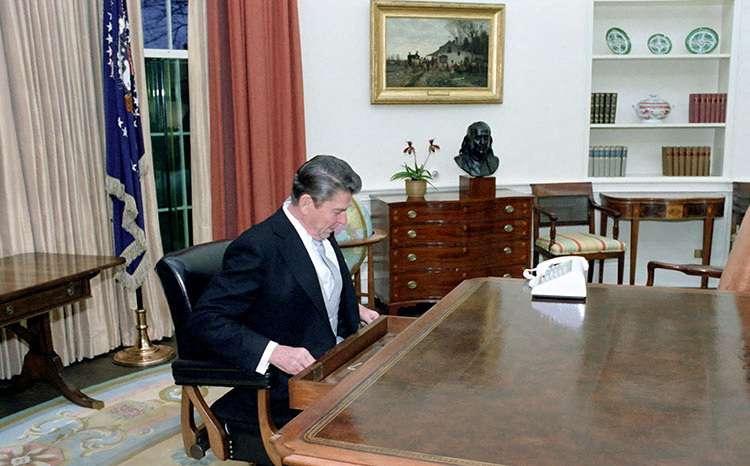 FILE PHOTO: Ronald Reagan sitting at the Oval Office desk following his inaugural parade