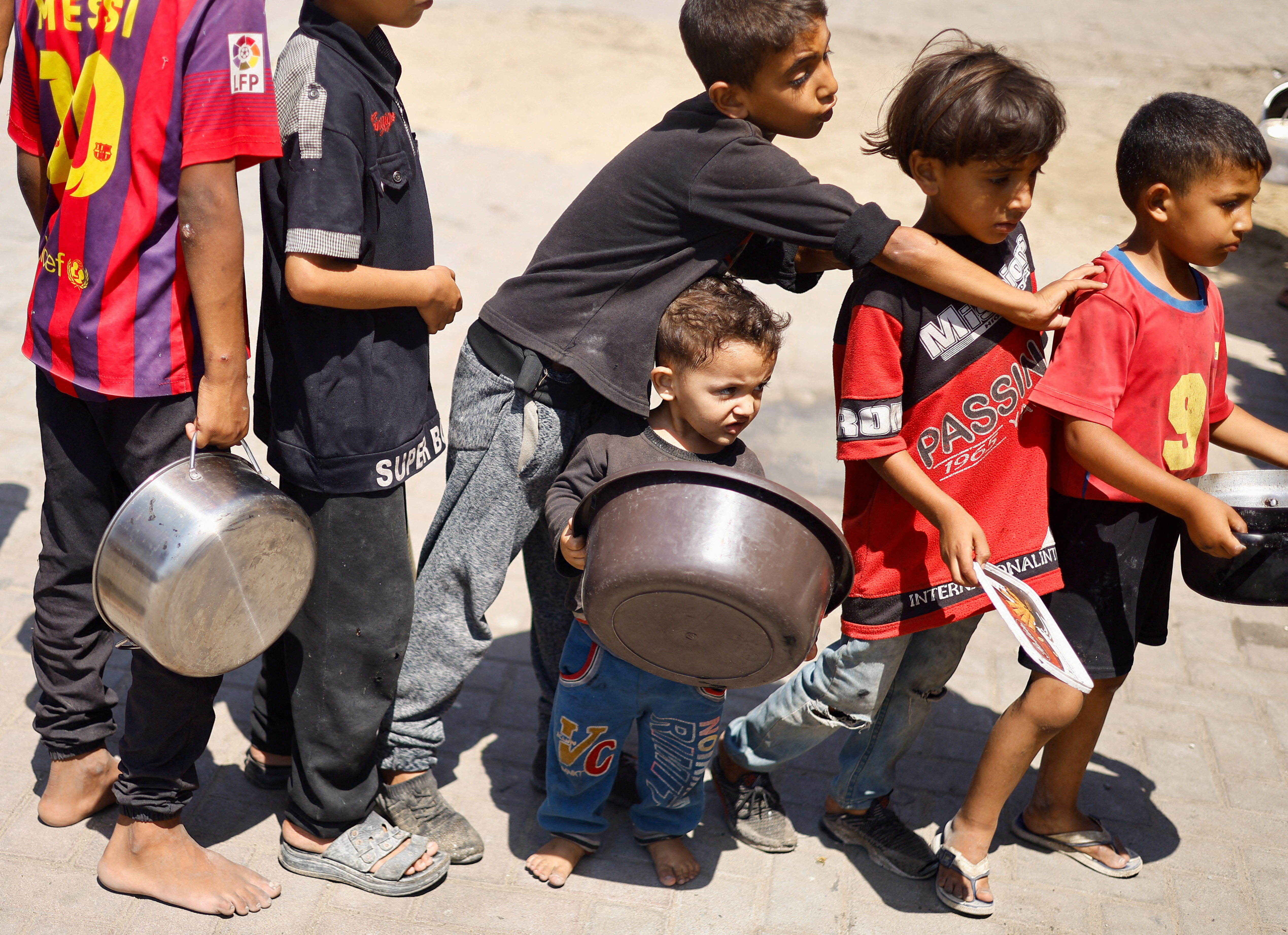 FILE PHOTO: Palestinians gather to receive food cooked by a charity kitchen, amid food scarcity, as Israel-Hamas conflict continues, in Khan Younis in the southern Gaza Strip