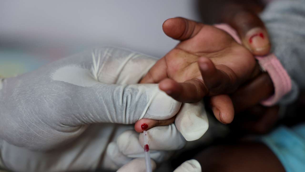 A nurse draws a blood sample from a child for an HIV test at a clinic in Diepsloot