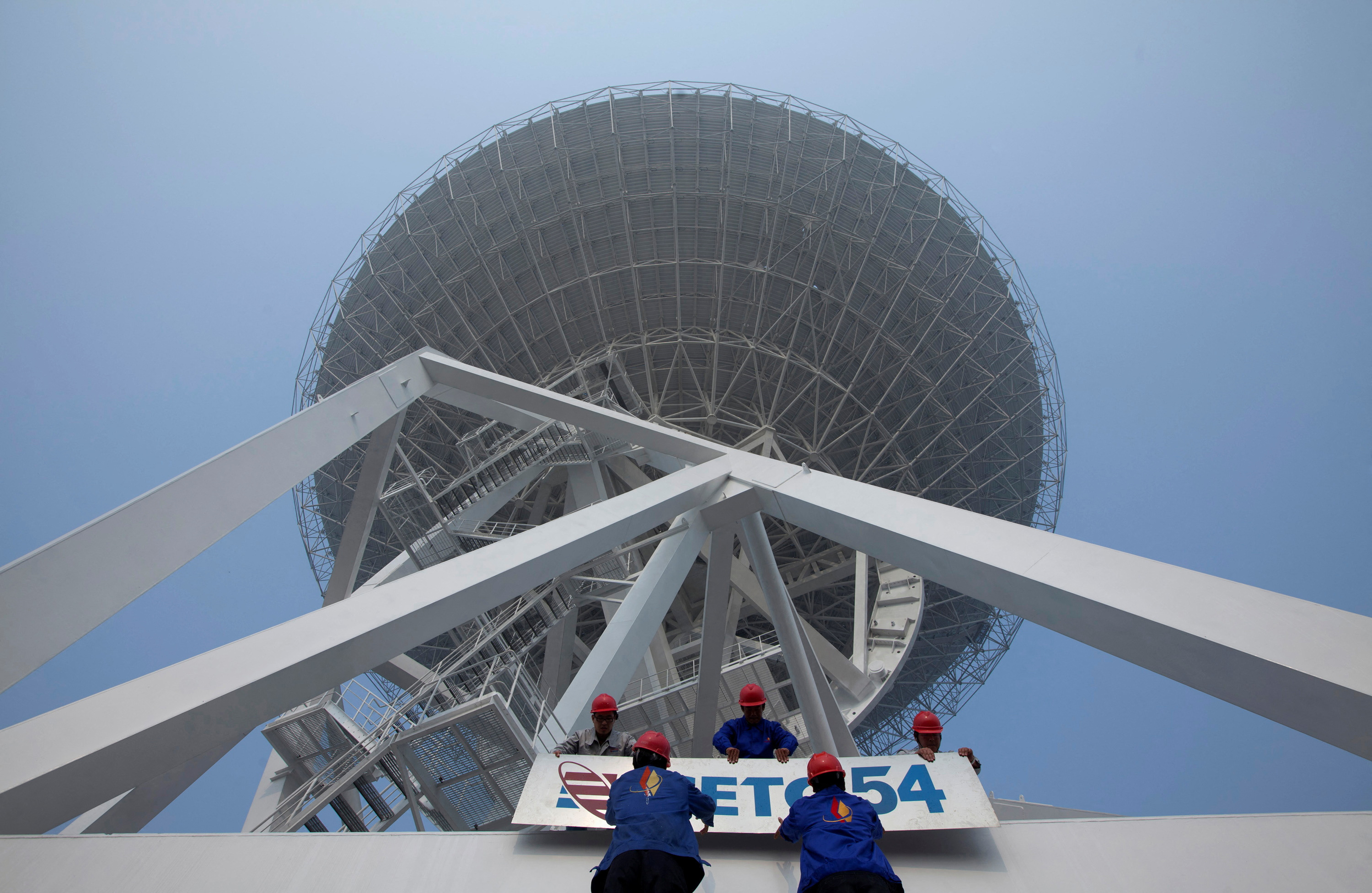 FILE PHOTO: Employees install a signage of the 54th Research Institute of CETC in Shanghai