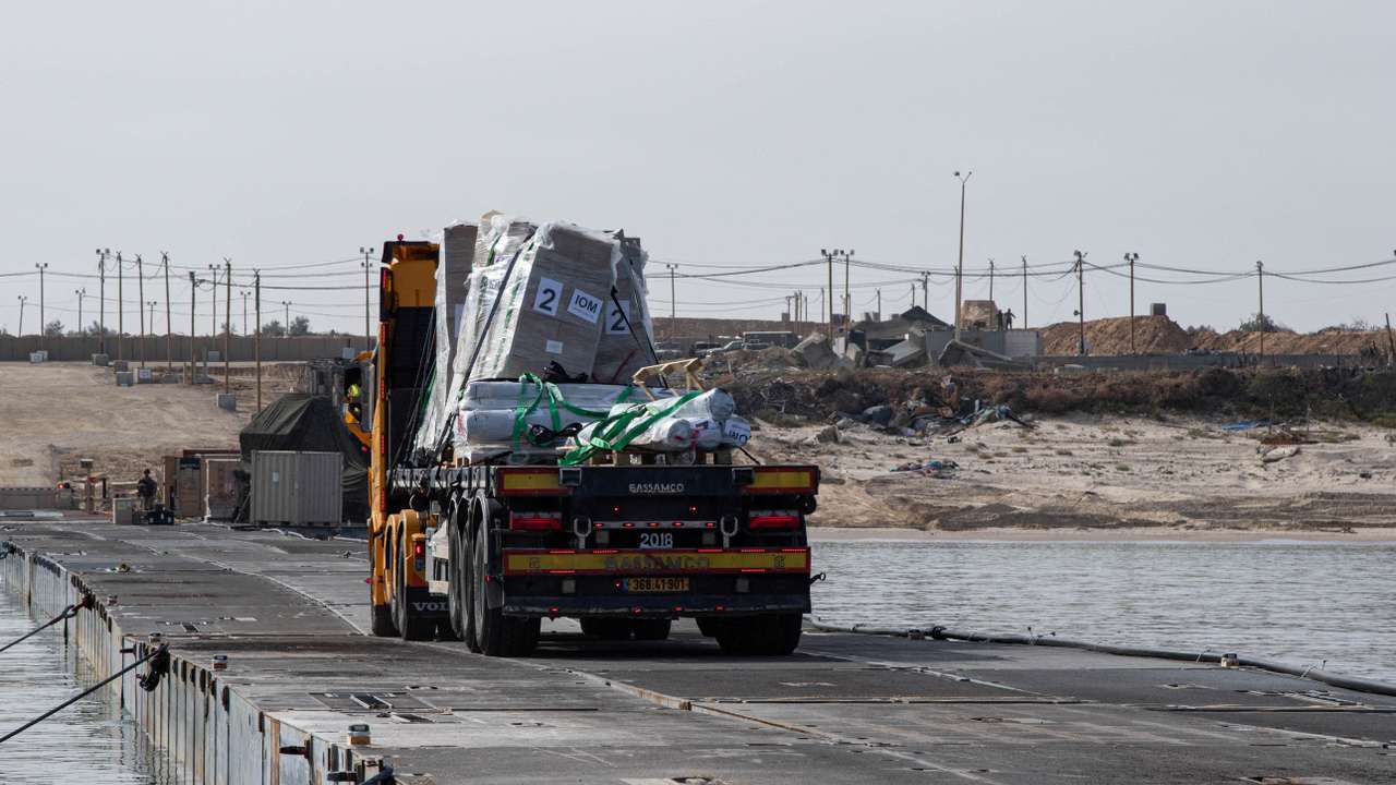 FILE PHOTO: Trucks deliver humanitarian aid over a temporary pier on the Gaza coast