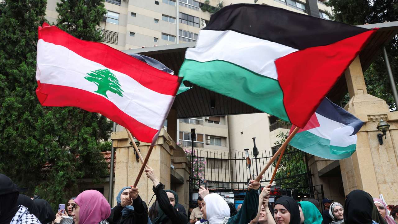 Demonstrators hold Lebanese and Palestinian flags during a protest in solidarity with Gaza at the Lebanese American University (LAU), in Beirut