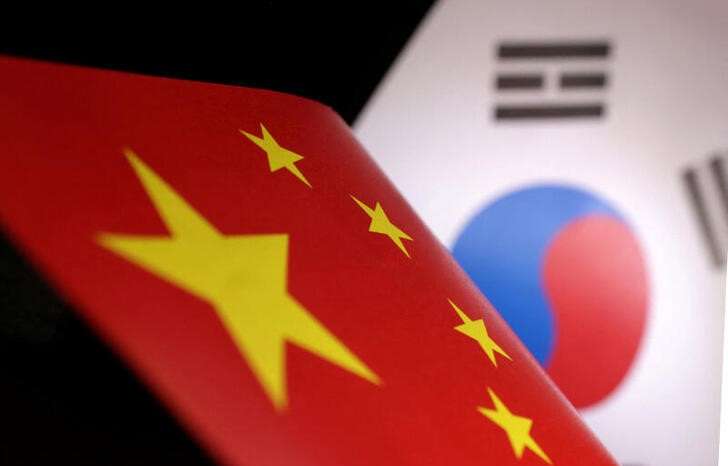 Illustration shows printed Chinese and South Korean flags