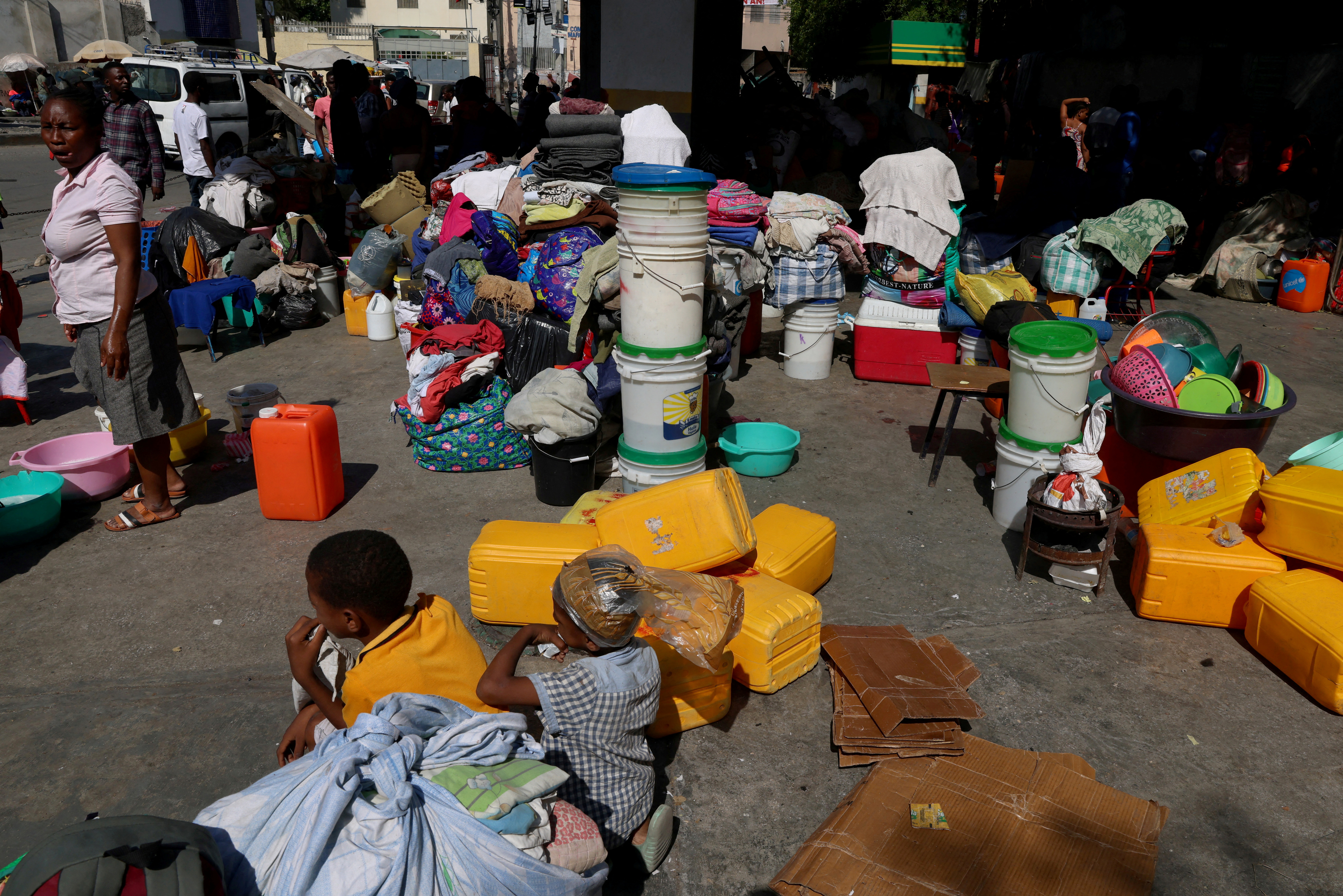 FILE PHOTO: People shelter at a petrol station amid ongoing gang violence