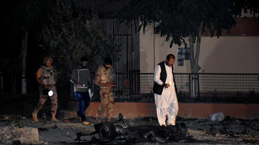 Security officers and paramilitary soldiers survey the site, after five suicide bombers tried to drive a vehicle laden with ammunition and explosives into a military facility in Quetta