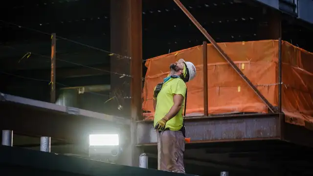 Imagem mostra trabalhador usando material de proteção EPI e olhando para cima