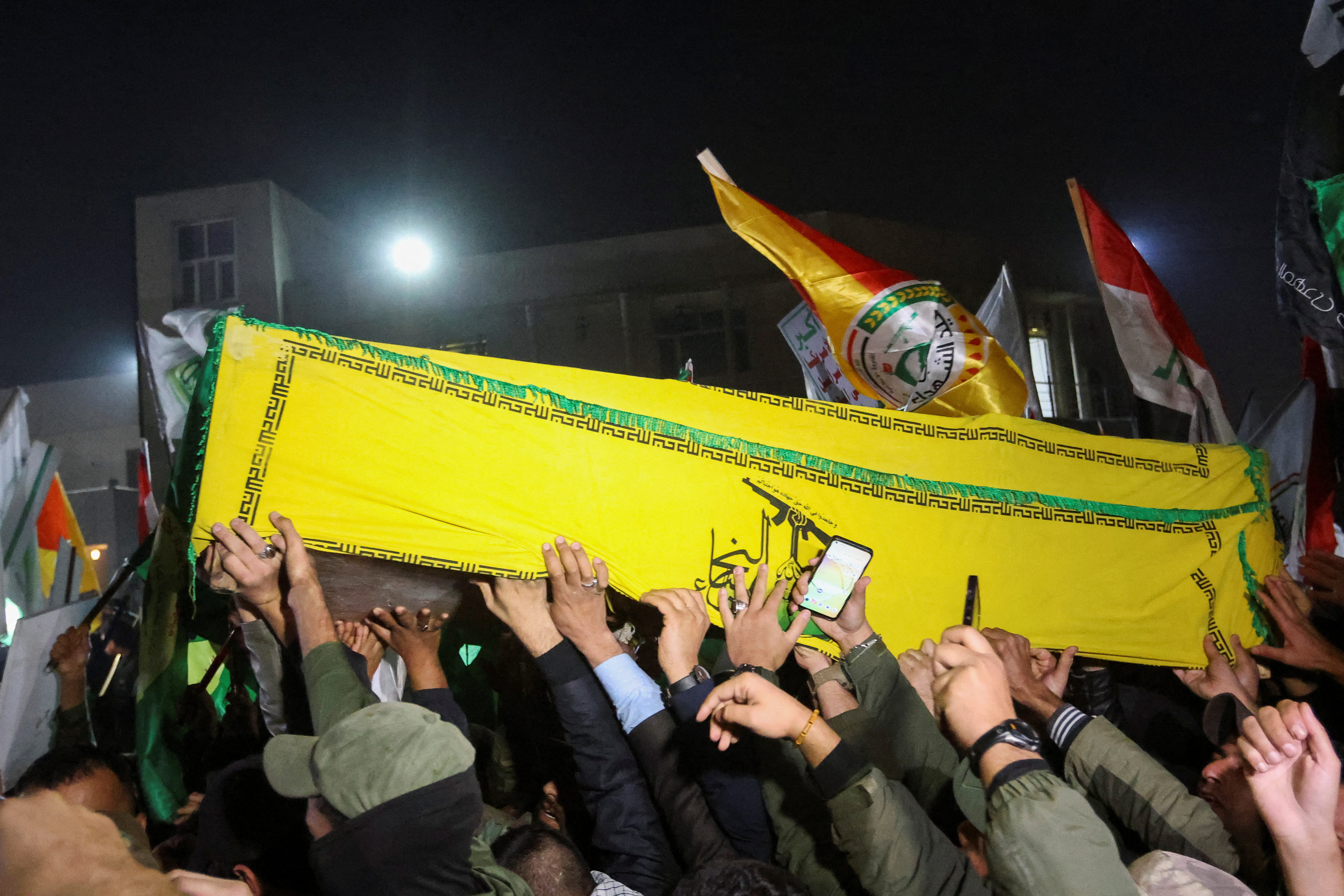 People carry the coffins of members of Harakat al-Nujaba killed by a U.S. military strike, in Baghdad