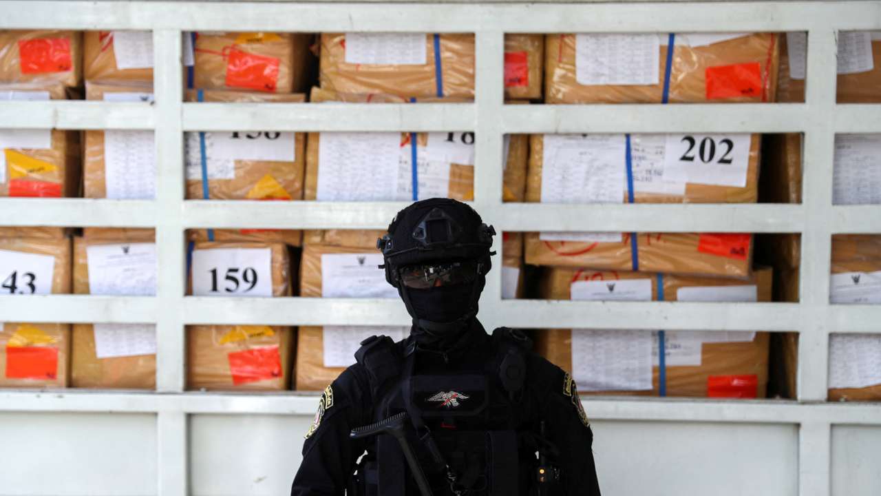 FILE PHOTO: A police officer from the Narcotics Control Board stands guard in front of boxes of confiscated drugs during the 50th Destruction of Confiscated Narcotics ceremony in Ayutthaya province