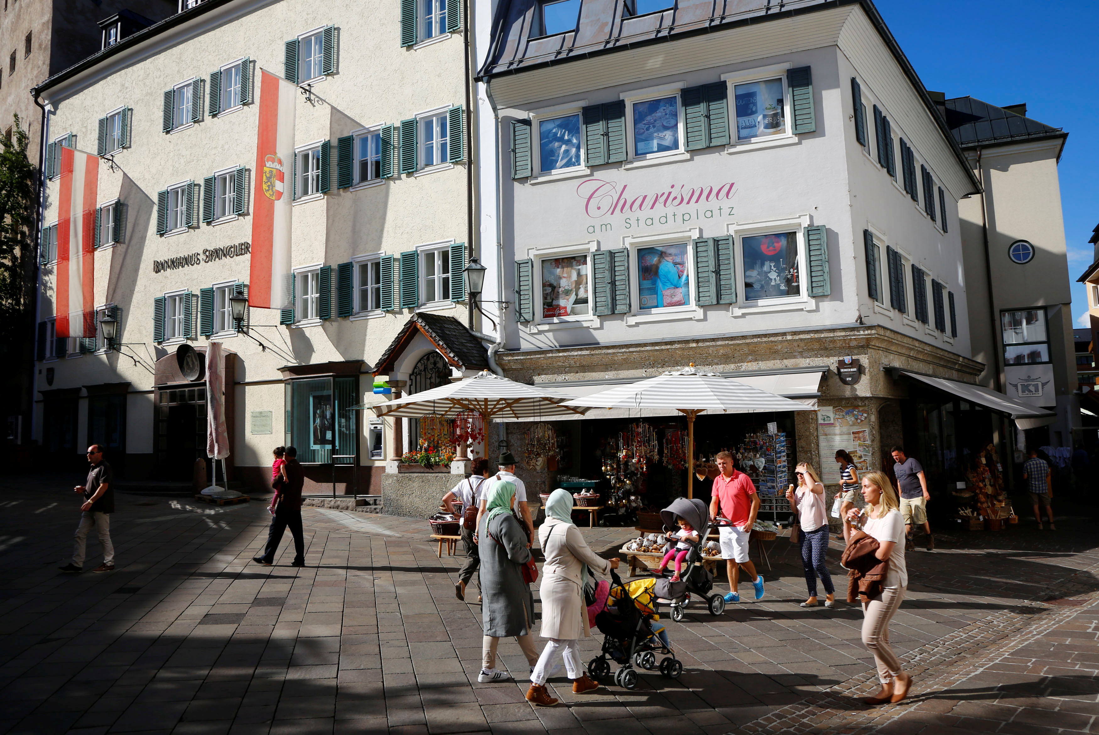 Arab tourists walk past a souvenir shop in Zell am See