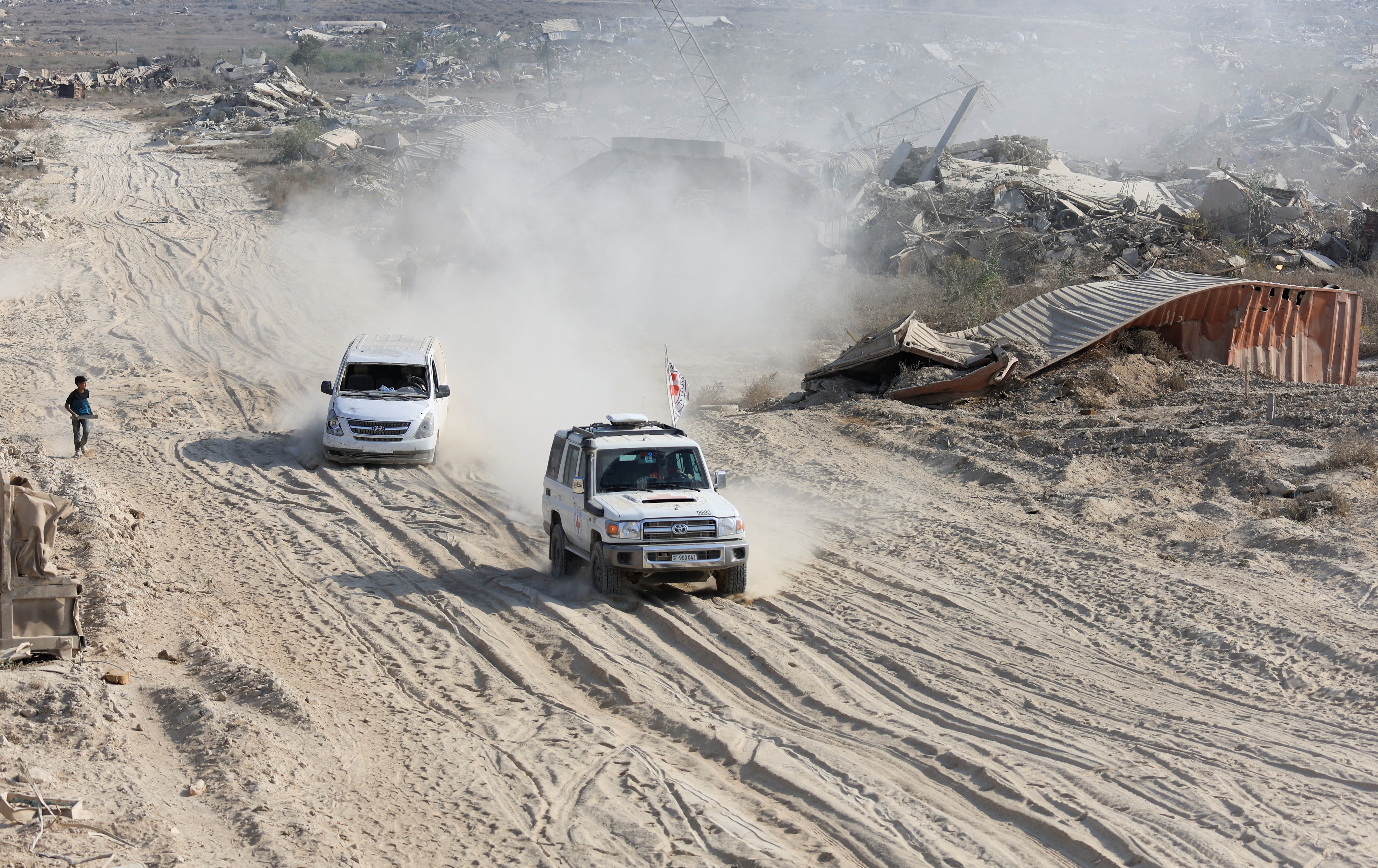 A Red Cross vehicle, escorted by a van driven by a Hamas militant, moves in an area within the so-called "yellow line" to which Israeli troops withdrew under the ceasefire, in Gaza City