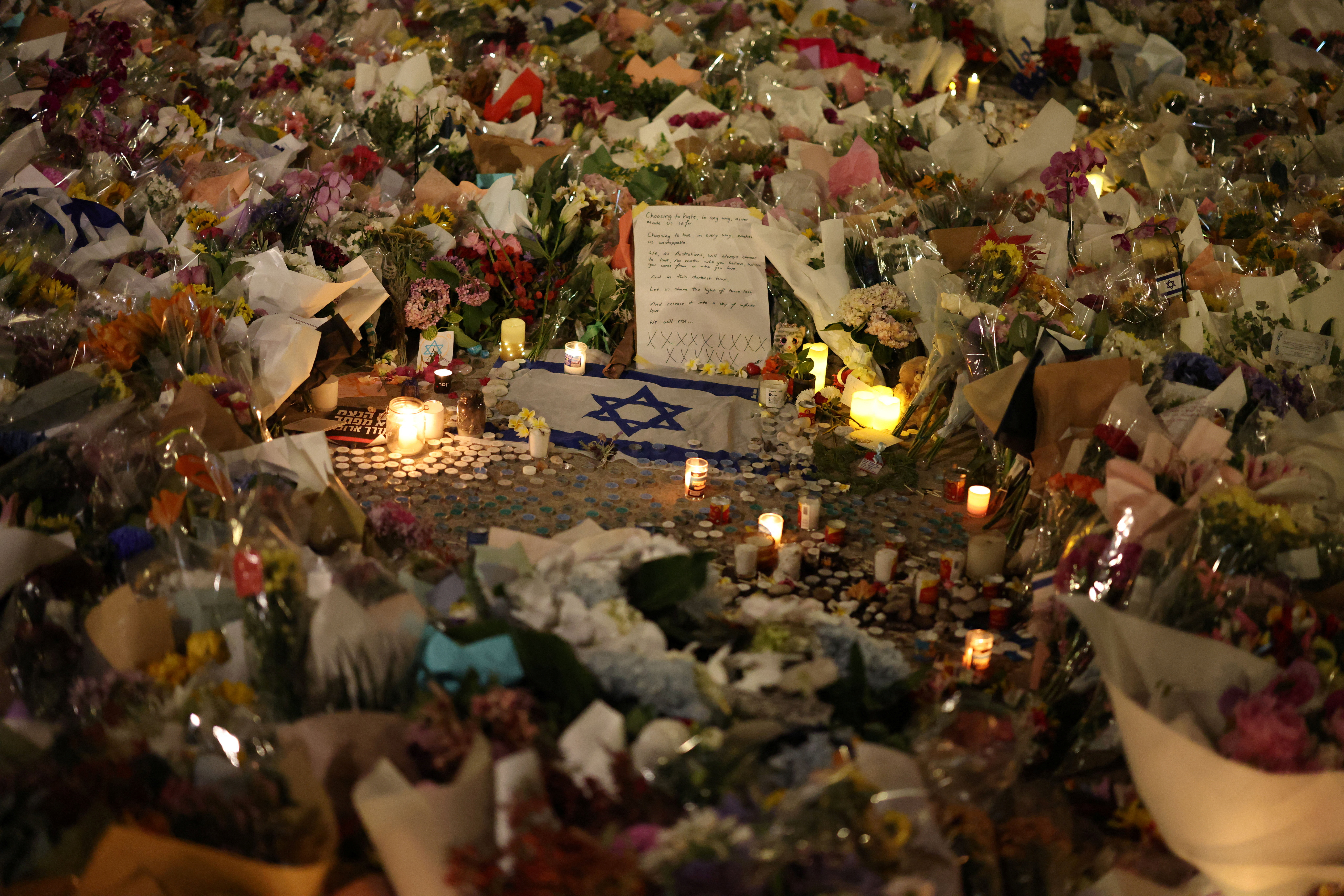 An Israeli flag sits amongst floral tributes honouring the victims of a shooting at Jewish holiday celebration on Sunday at Bondi Beach, in Sydney