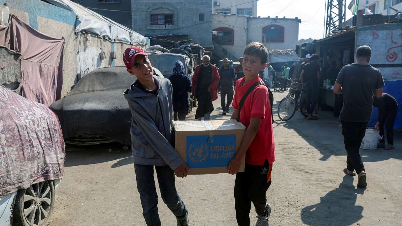 FILE PHOTO: Palestinians receive aid from UNRWA in Deir Al-Balah, central Gaza Strip