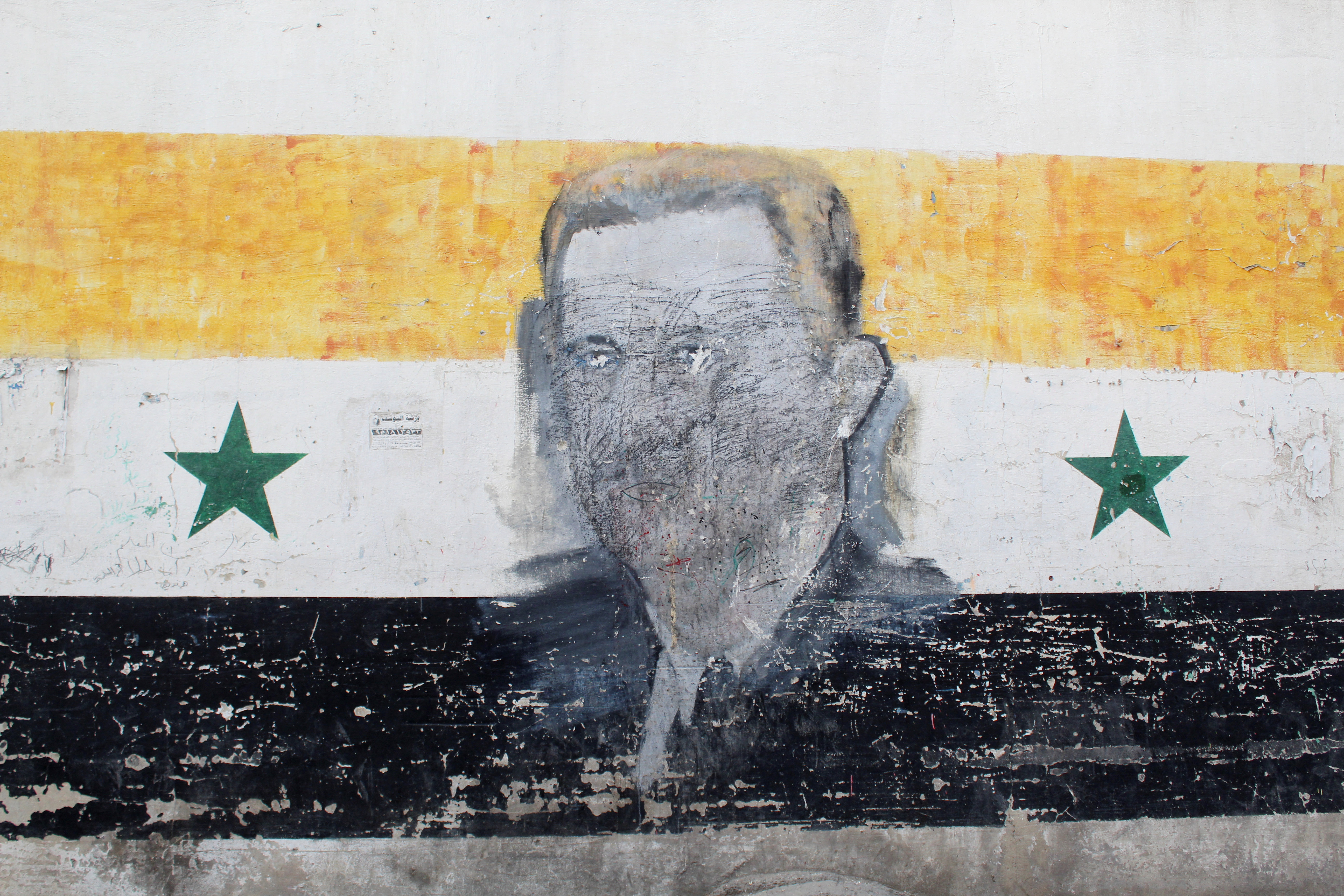 A wall painted with a damaged drawing of ousted Syrian President Bashar al-Assad is pictured in the al-Qadam neighbourhood' in Damascus