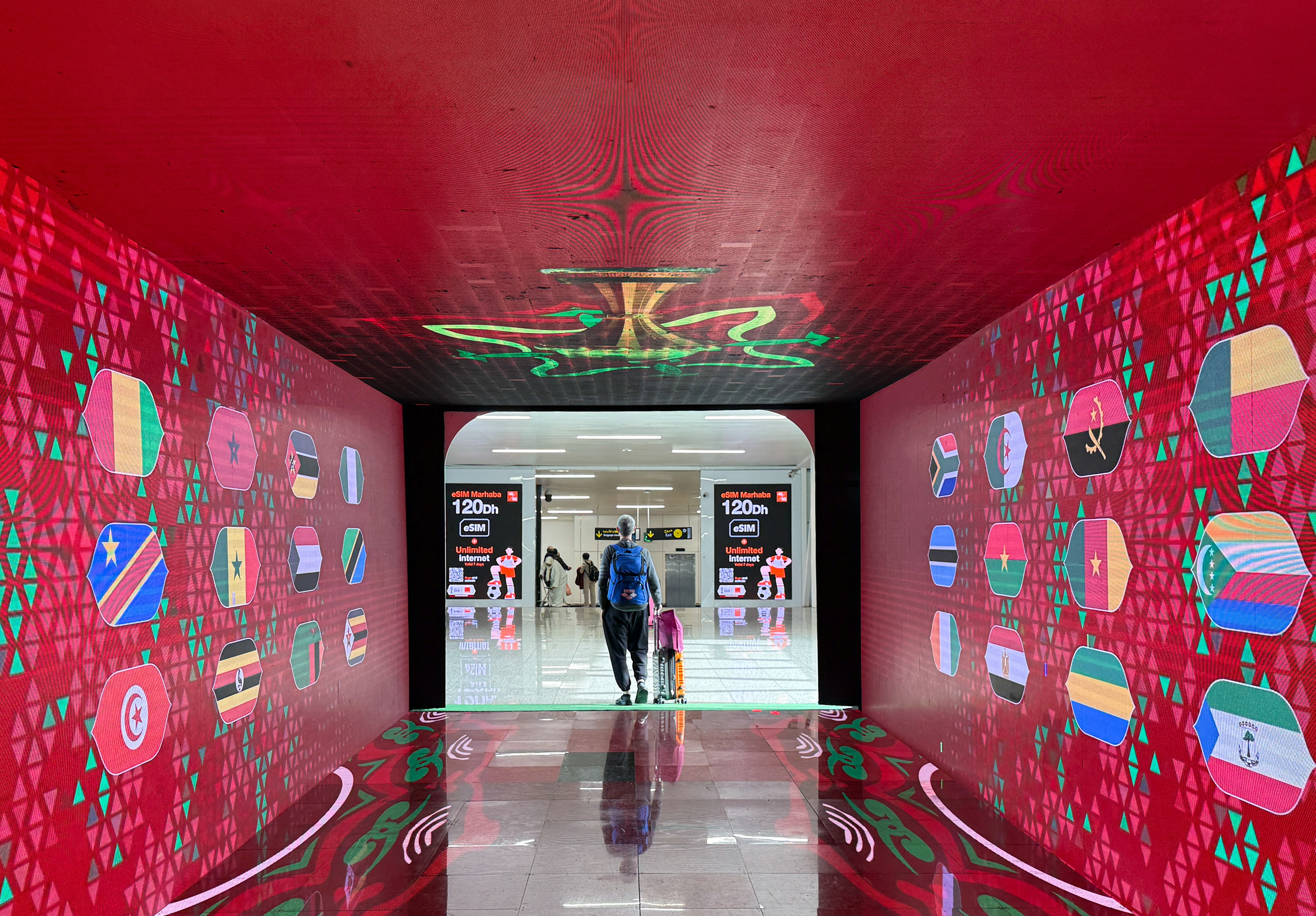 A passenger walks past themed decoration of the African Cup of Nations (AFCON)