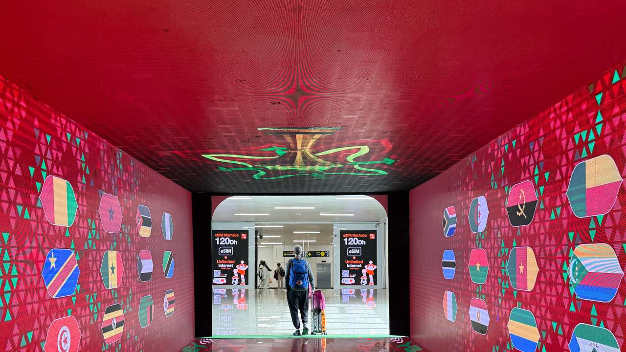 A passenger walks past themed decoration of the African Cup of Nations (AFCON)