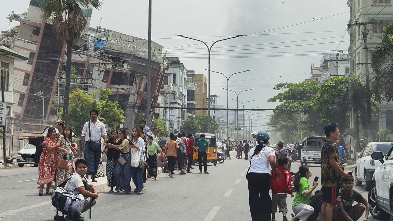 People gather on a street near damaged buildings after a strong earthquake struck central Myanmar
