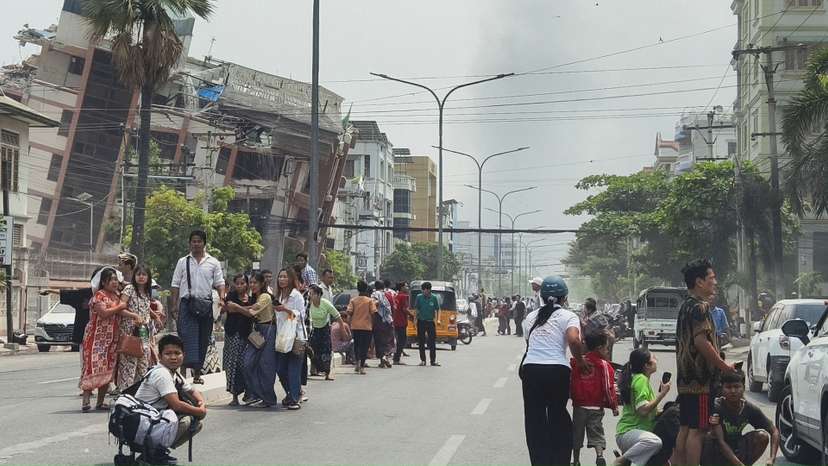 People gather on a street near damaged buildings after a strong earthquake struck central Myanmar