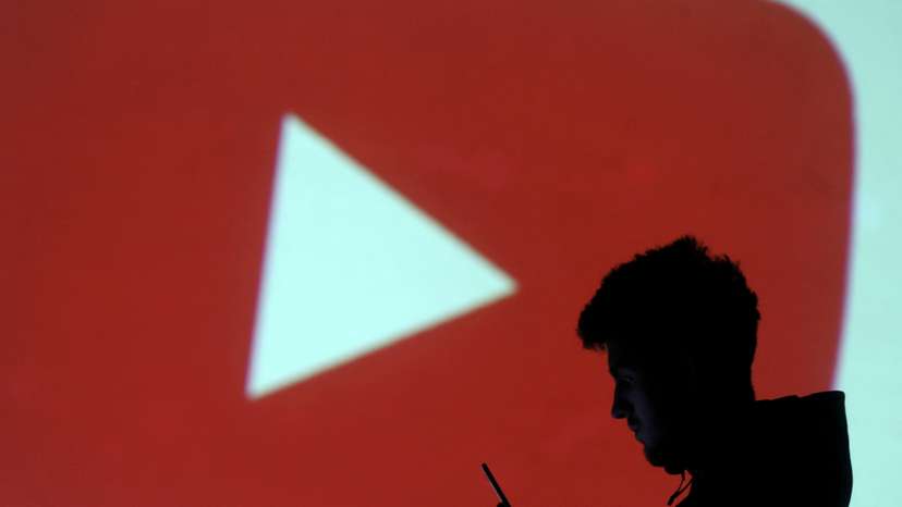 FILE PHOTO: A silhouette of a mobile user is seen next to a screen projection of Youtube logo in this picture illustration