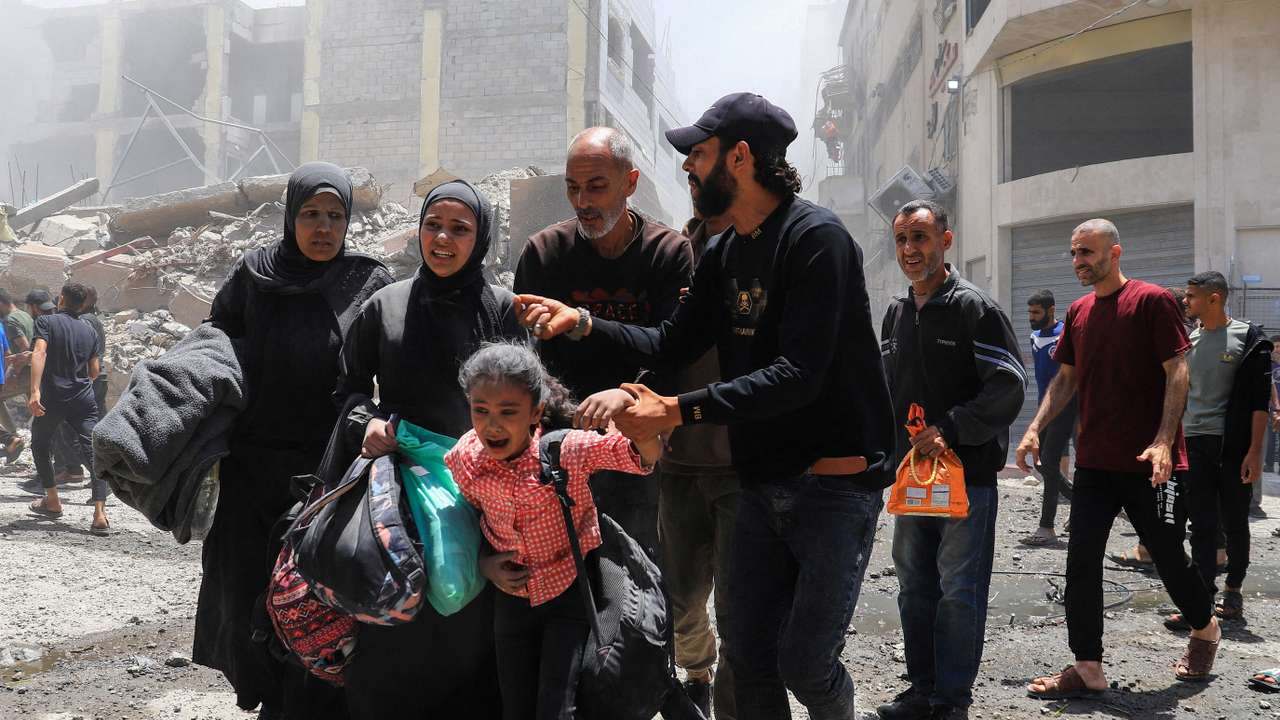 Palestinians evacuate in the aftermath of an Israeli strike on a house, in Gaza City