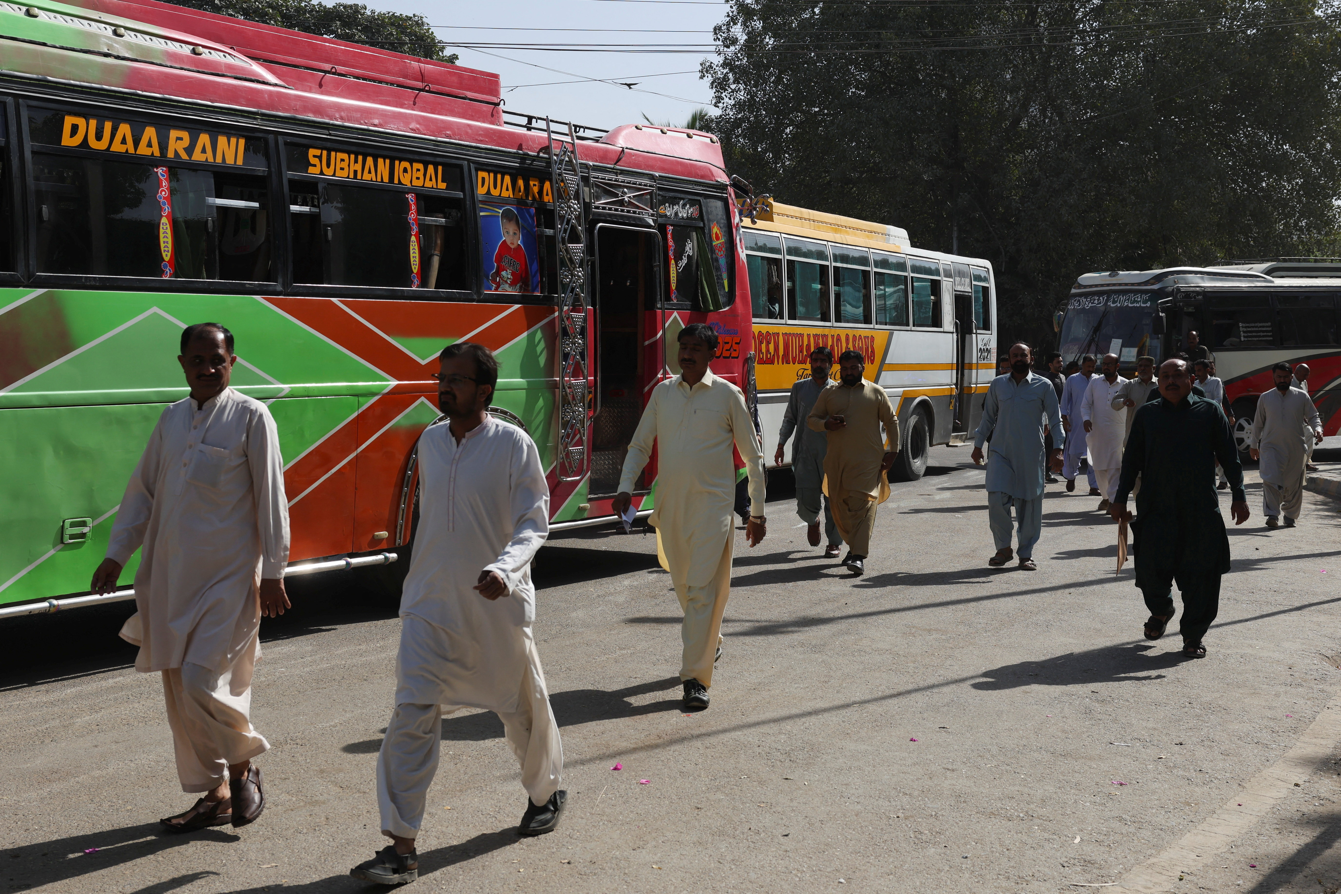 Government employees walk as they arrive to work at the provincial Sindh Secretariat building, in Karachi