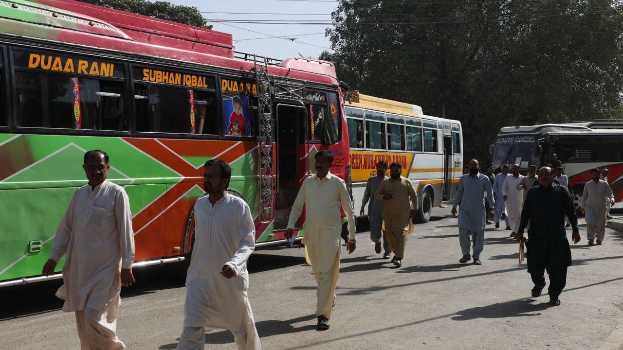 Government employees walk as they arrive to work at the provincial Sindh Secretariat building, in Karachi