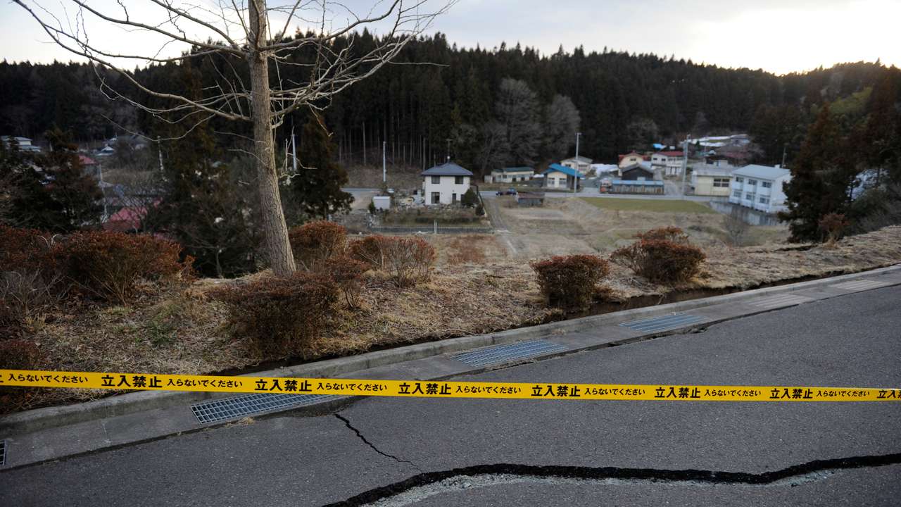 A police tape barring cars and people from entering, is placed across an area in Ono