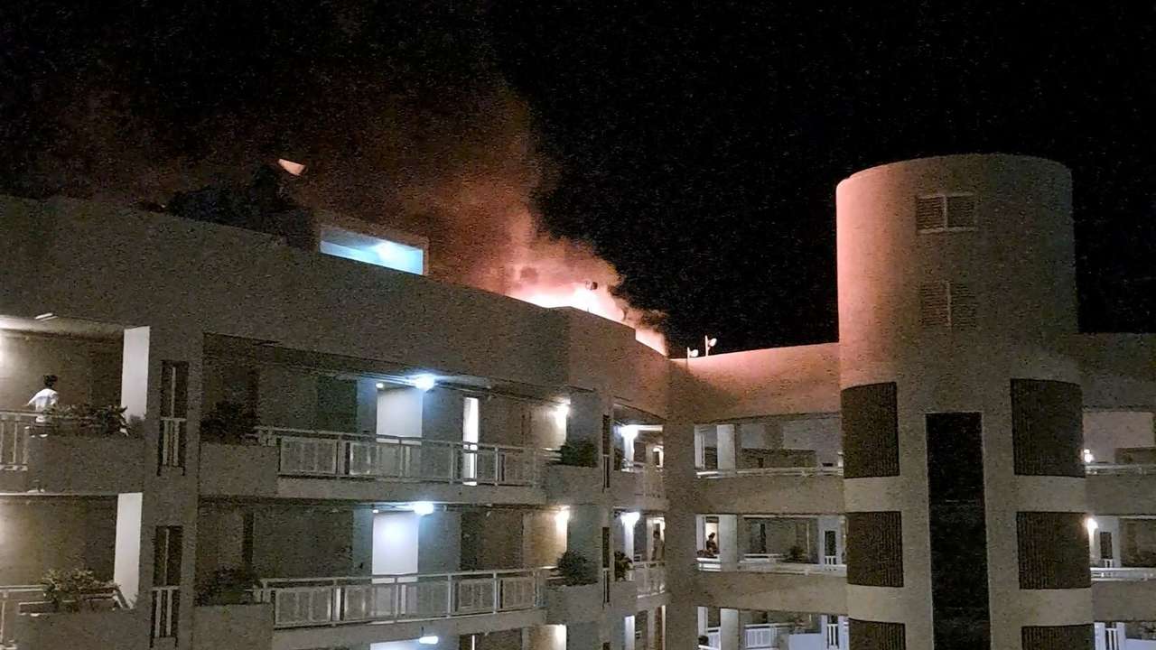 A fire burns at the Double Tree Hotel after a helicopter crashed into the roof in Cairns