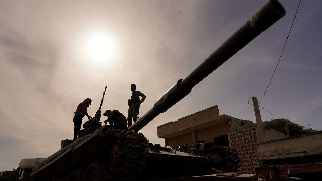 Syrian troops sit atop tank as they head towards the Syrian-Lebanese border following clashes with Lebanese soldiers and armed groups, in Qusayr
