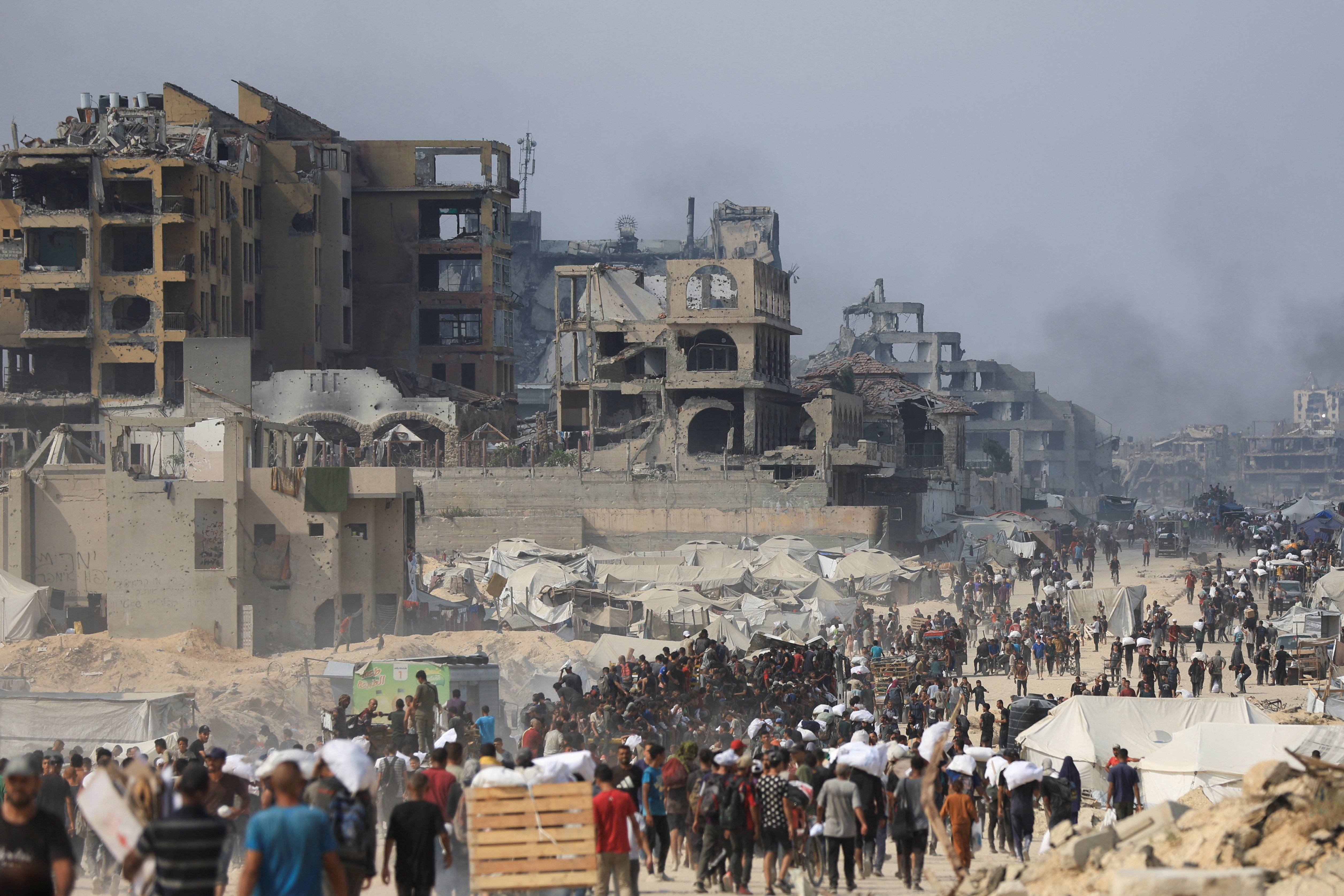 Palestinians seek aid supplies from trucks that entered Gaza through Israel, in Beit Lahia, in the northern Gaza Strip