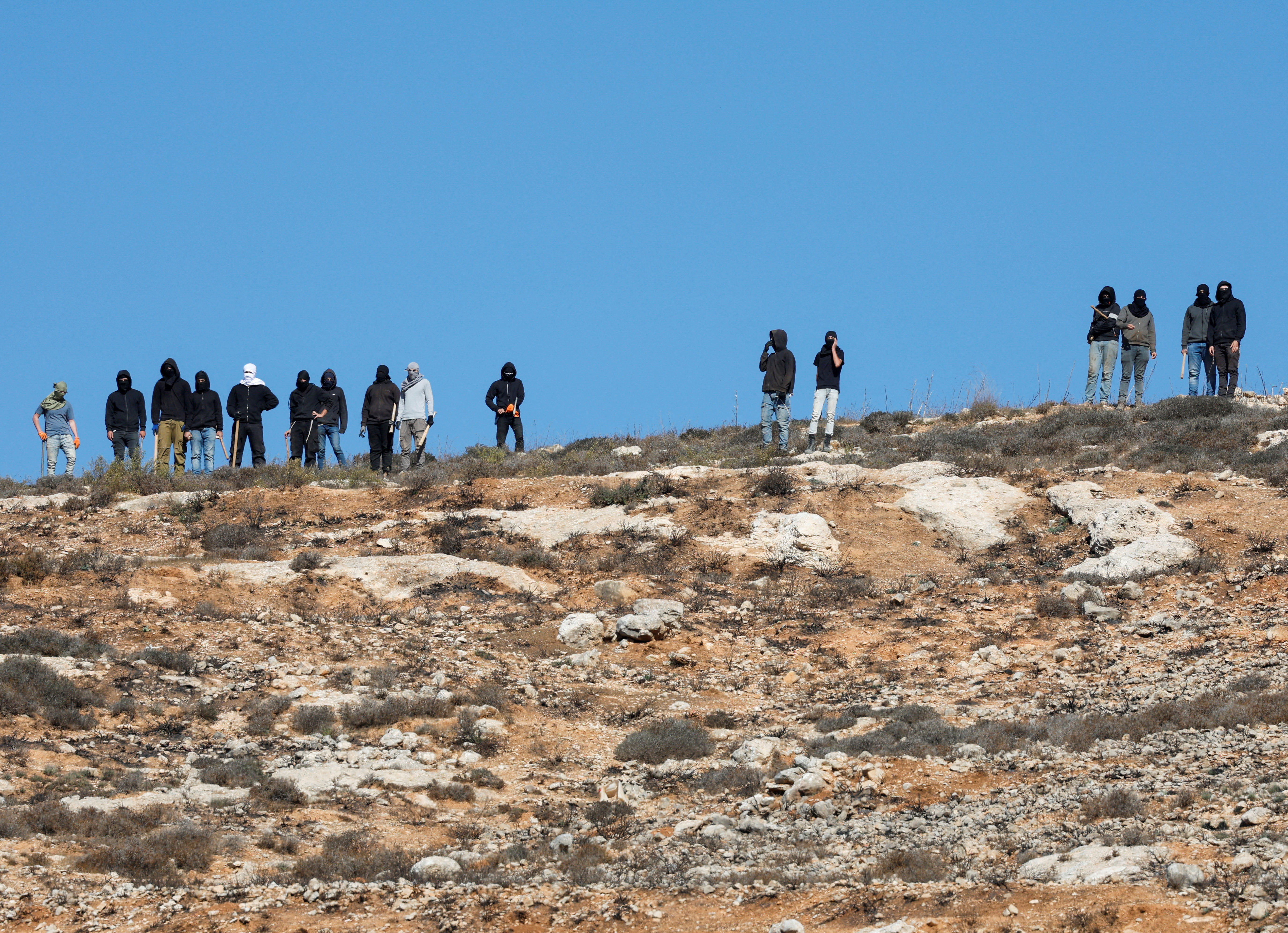 FILE PHOTO: Israeli troops deny Palestinian farmers access to harvest olives, in Burqa