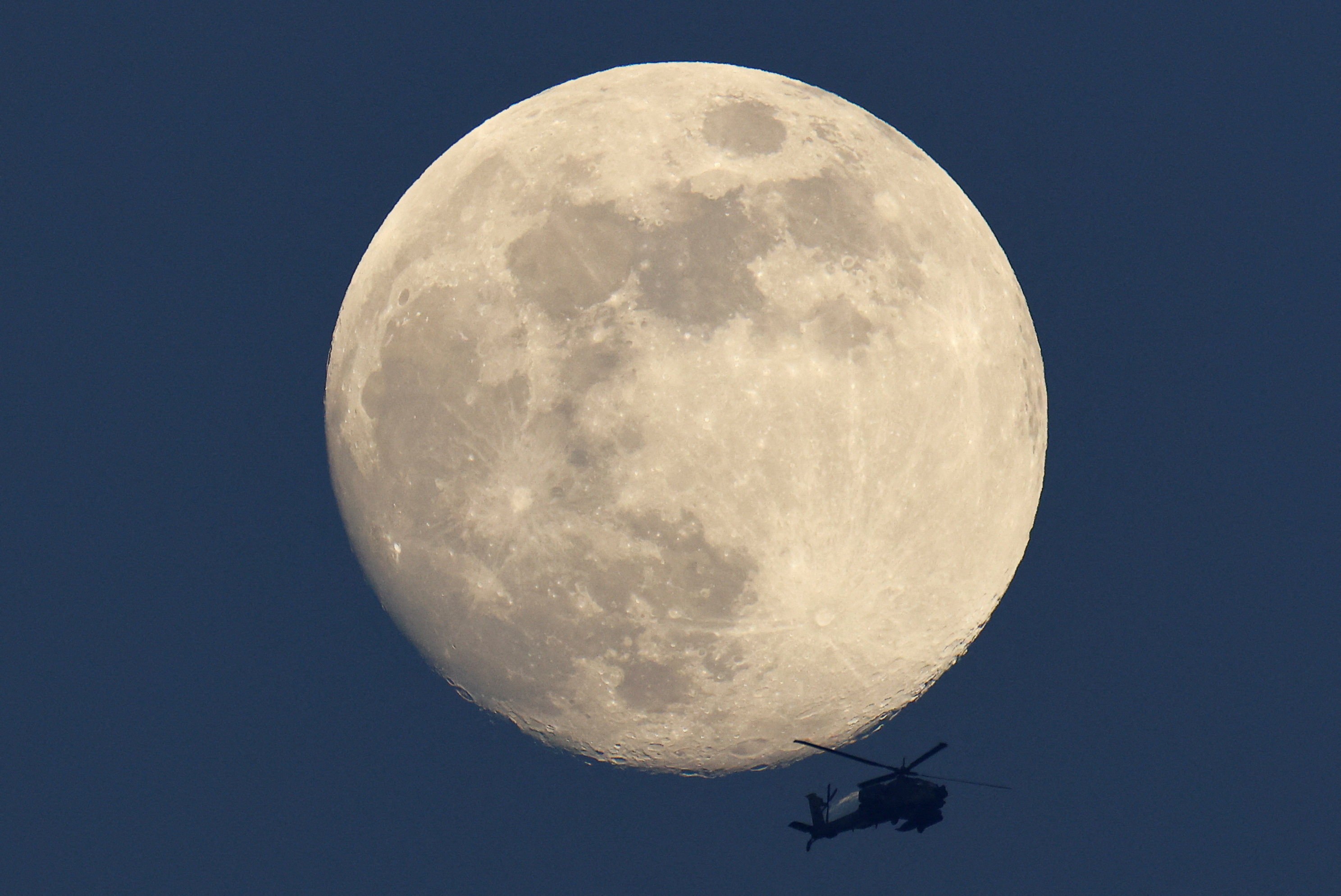 Apache helicopter passes in front of the moon, near the Israel-Gaza border