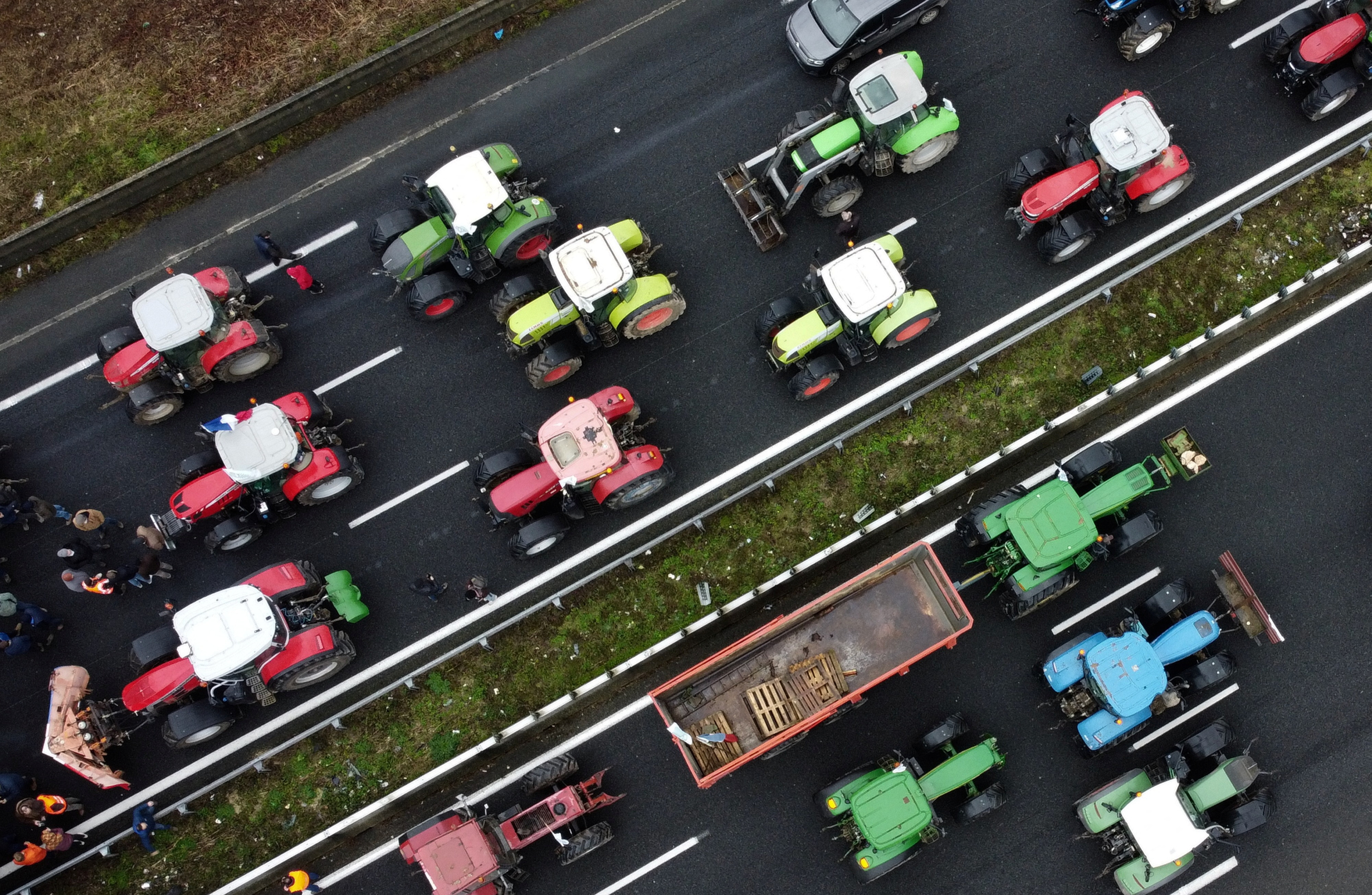 French farmers use their tractors to block the A1 highway near a highway toll station in Chamant