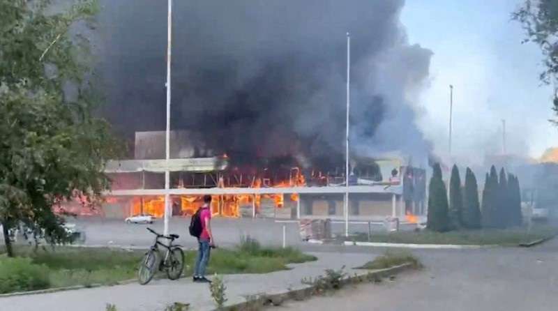Smoke and flames rise from a shopping center damaged by shelling, in Donetsk