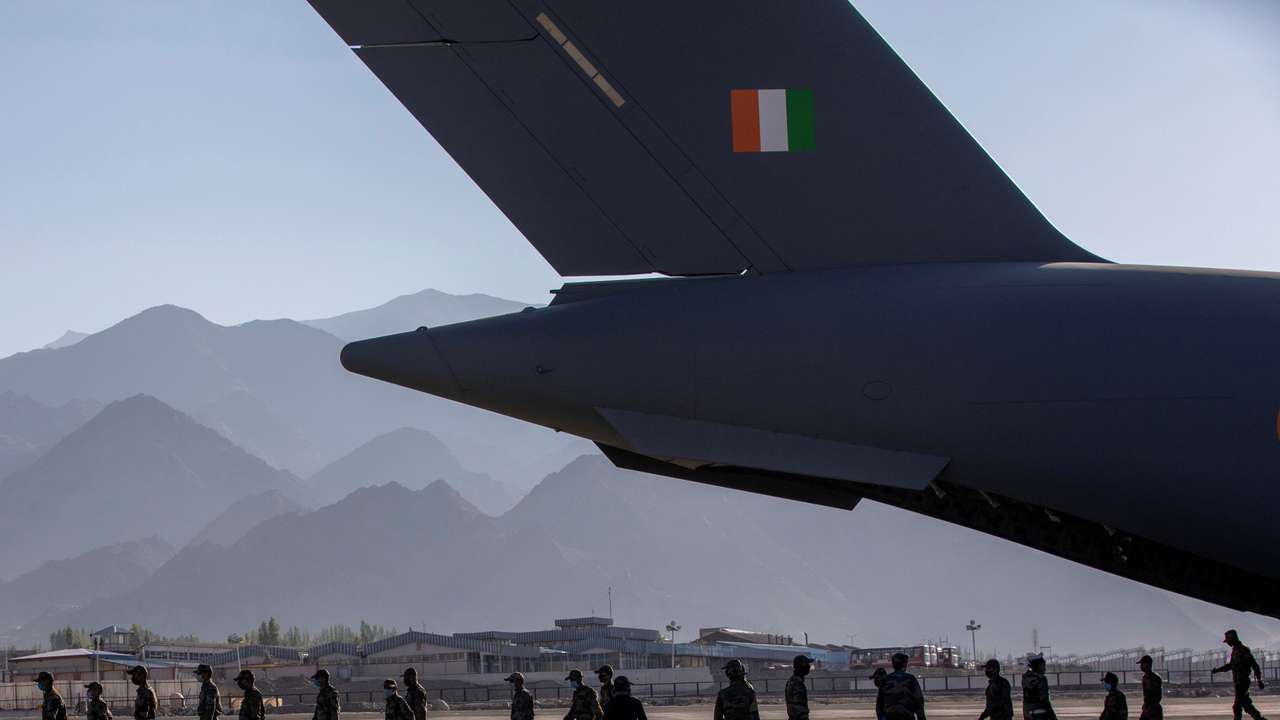 Indian soldiers disembark from a military transport plane at a forward airbase in Leh