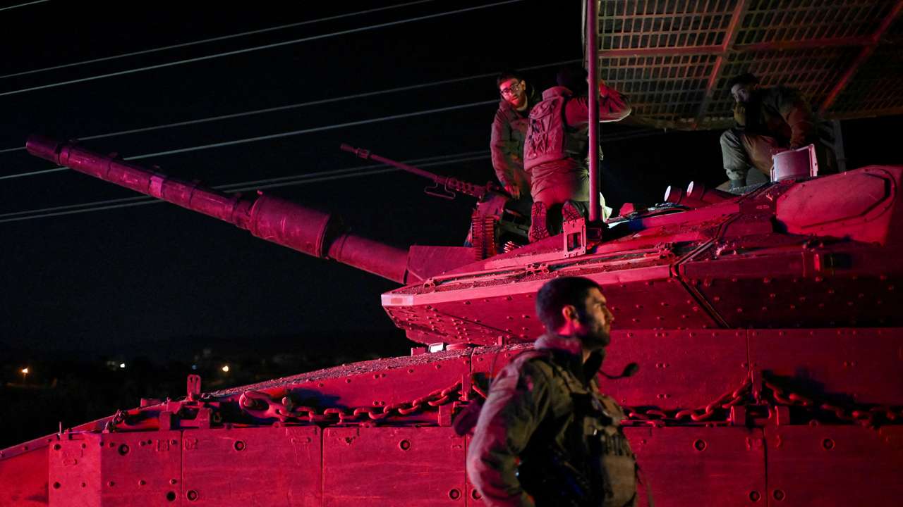 Israeli soldiers gather near a military vehicle after returning from Lebanon, following a ceasefire between Israel and Iran-backed group Hezbollah, near Kiryat Shmona